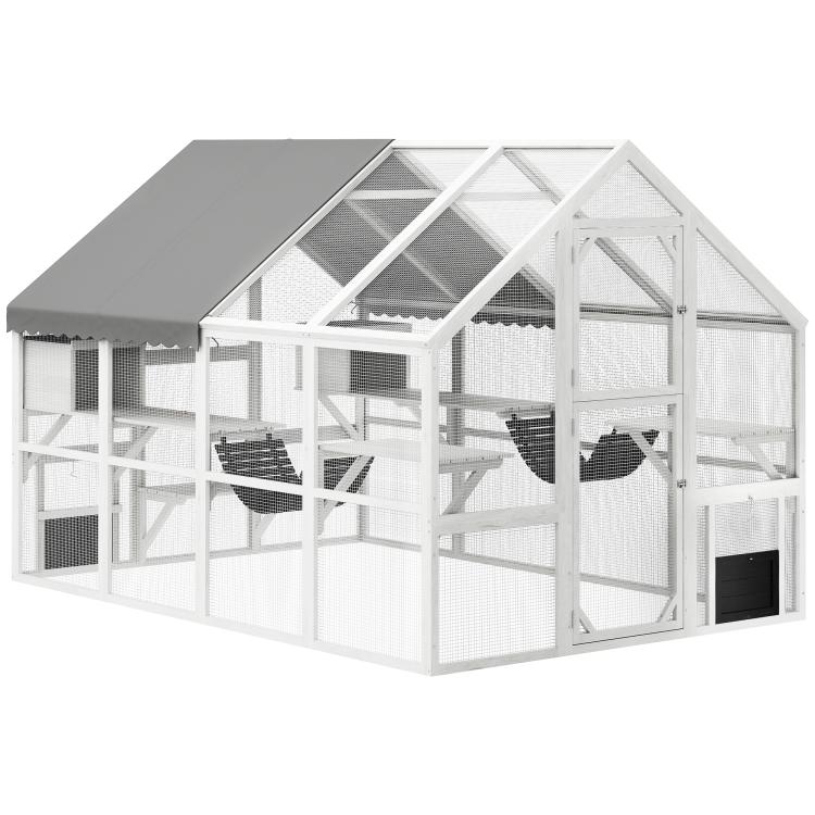 White wooden outdoor cat enclosure with mesh sides, multi-compartment interior, gabled roof