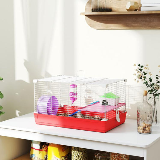 Red and white hamster cage on a tabletop with white wire enclosure and colorful accessories