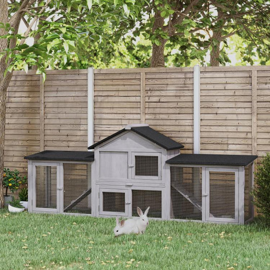 Gray outdoor wooden rabbit hutch with two levels, side runs, and front entrance