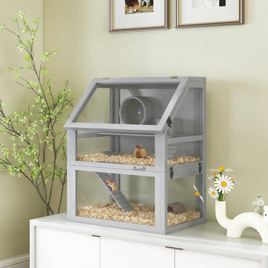 Gray wooden 3-tier hamster cage with ramp, wheel, and hut on indoor floor