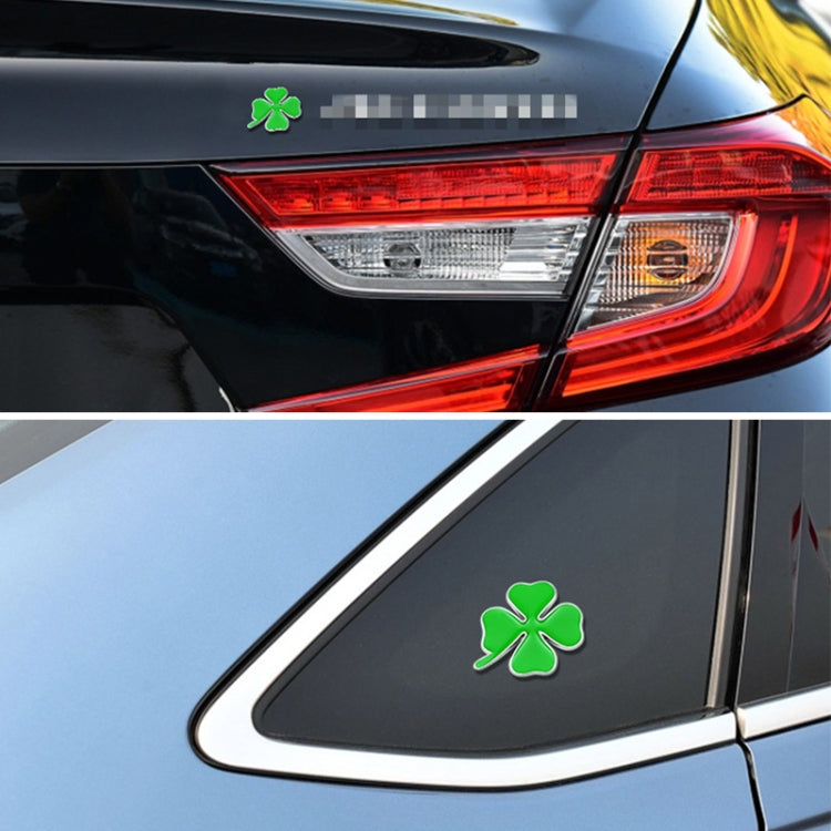 Green four-leaf clover sticker on a car trunk panel near the taillight