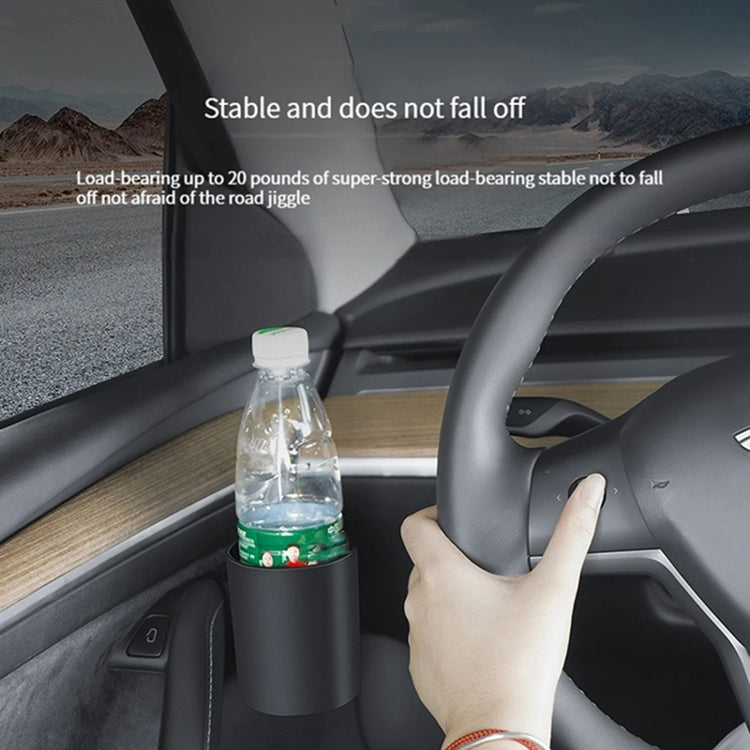 Car door cup holder holding a water bottle near the steering area