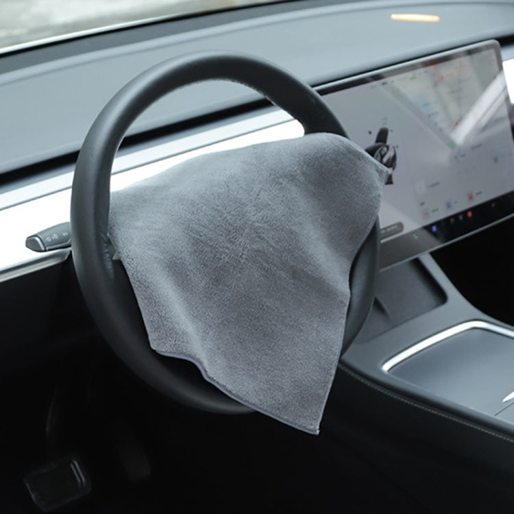 Gray microfiber towel with logo, draped over steering wheel