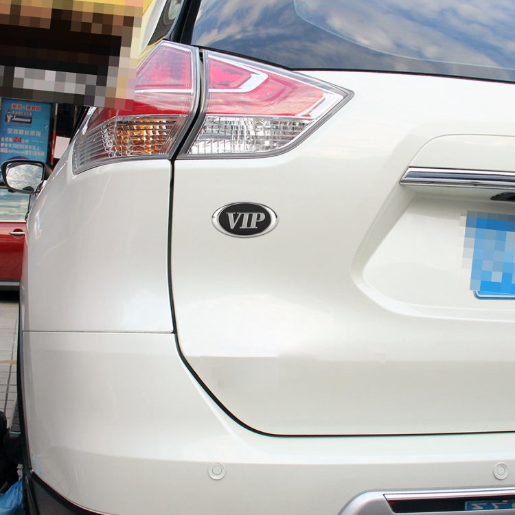 Oval VIP metal decorative sticker on white car body, chrome rim and black center