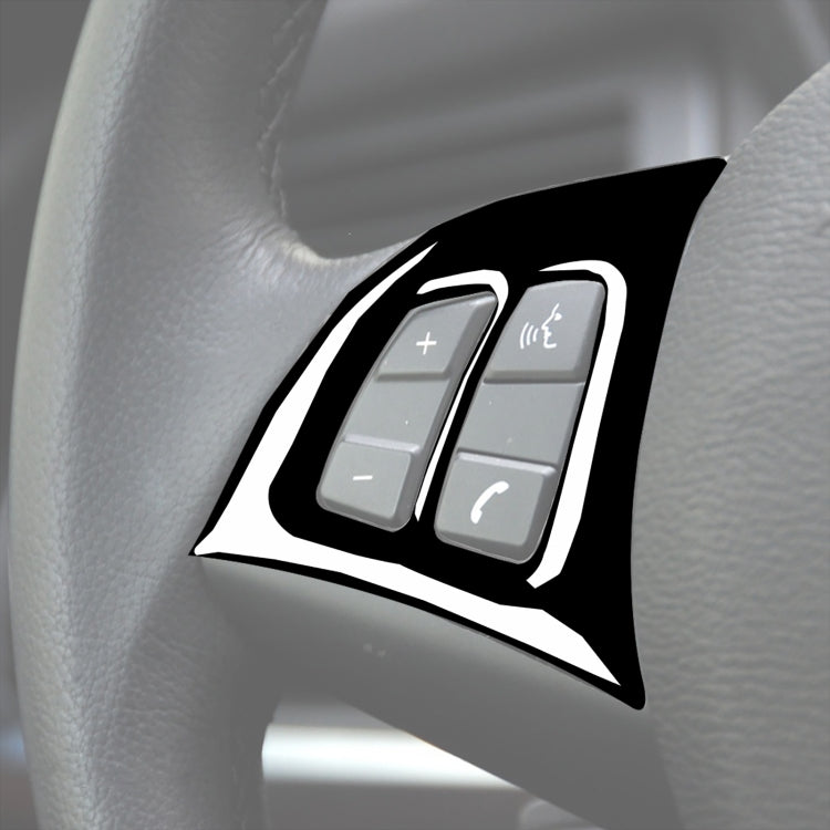 Steering wheel button sticker, black with white border, on light gray steering wheel