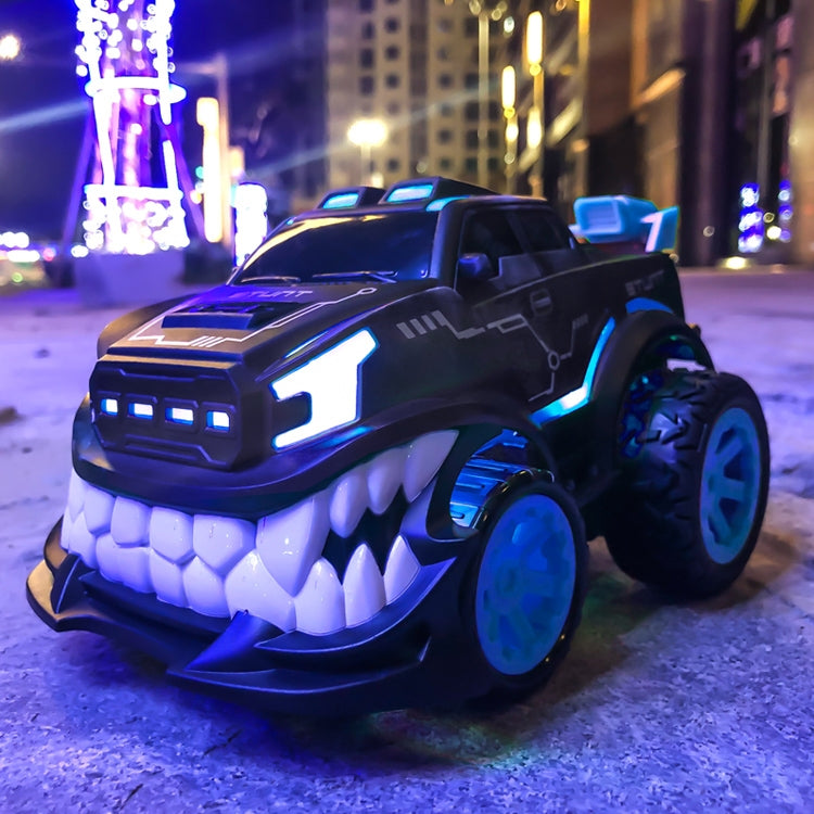 Blue-lit black remote control stunt car with white tooth grille and chunky tires