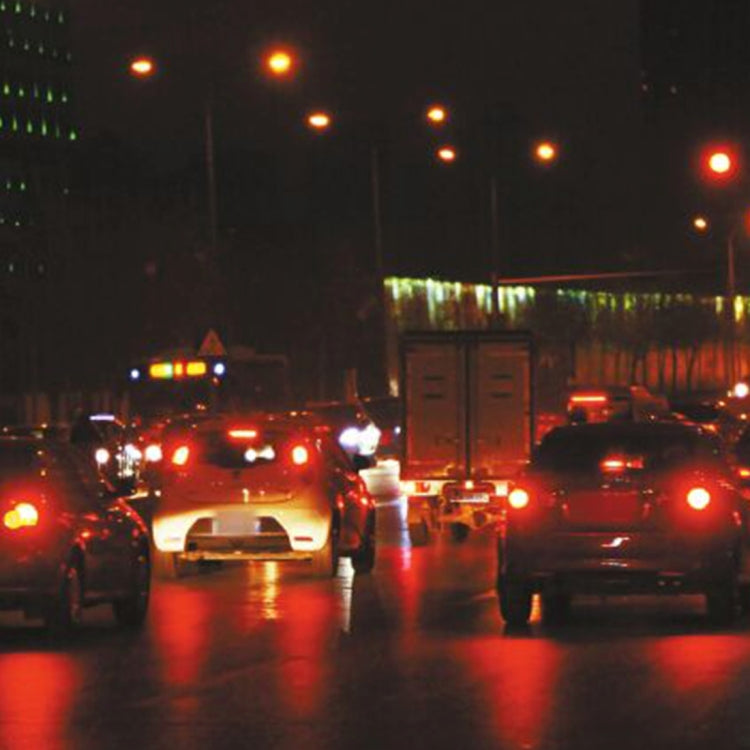Night traffic scene with cars showing red brake lights and signal lights glowing