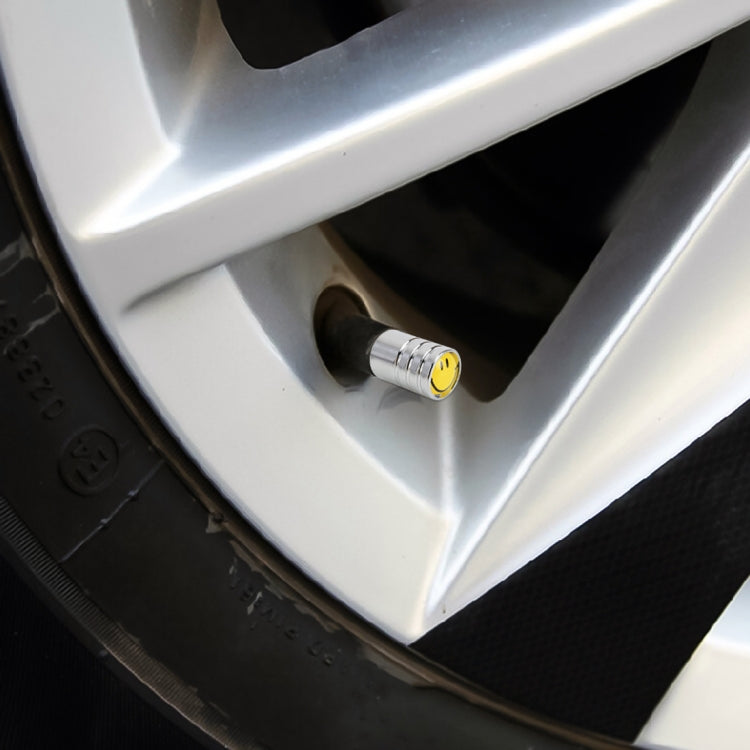 Yellow smile valve cap installed on a car tire valve stem