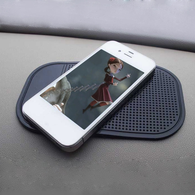 Car anti-slip phone mat, dark perforated pad supporting a smartphone on a dashboard.