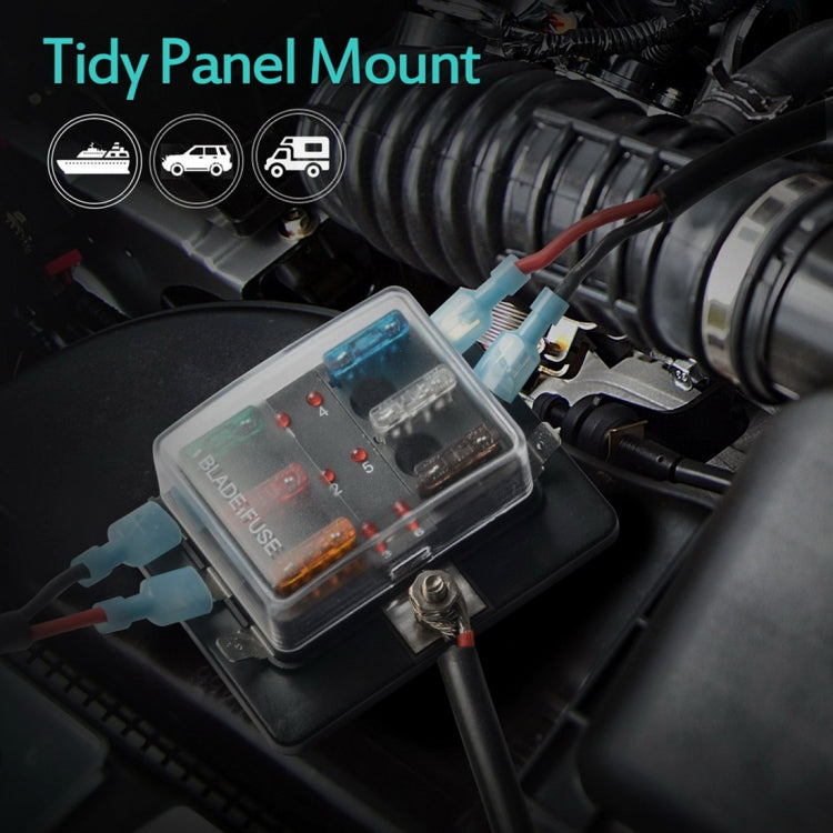 Black 6-way fuse block with transparent lid and colored blade fuses beside vehicle wiring