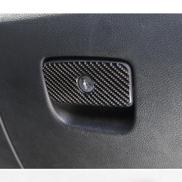 Carbon fiber seat storage sticker on dark upholstery, rectangular panel with round center hole