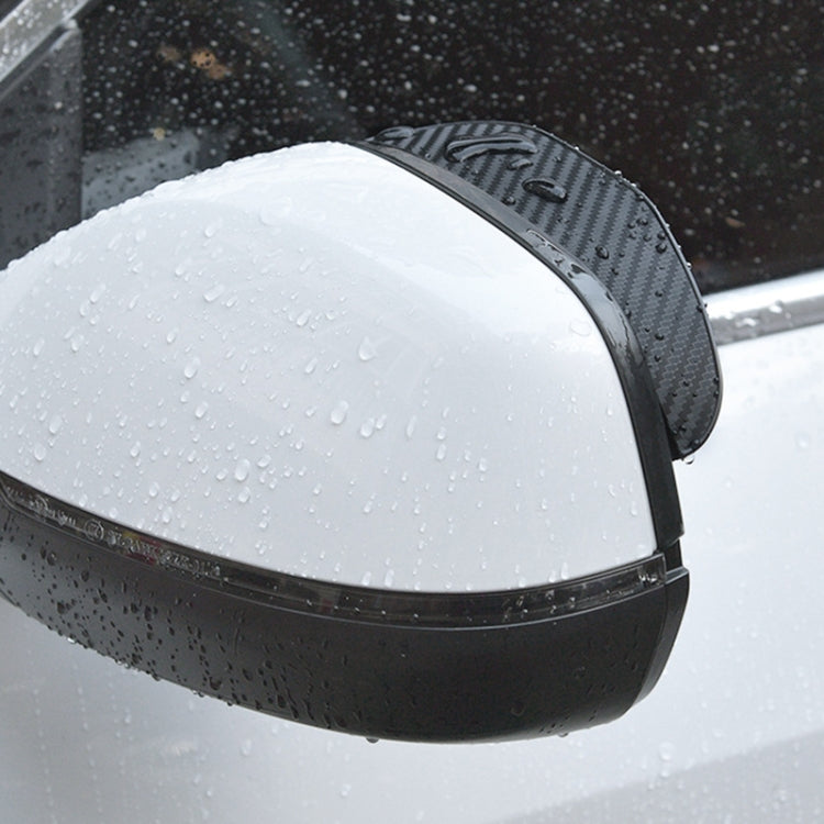 Black rearview mirror rain guard with carbon-fiber top and water droplets, curved cover