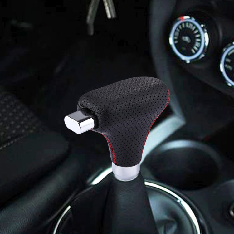 Black perforated leather shifter cover with red stitching mounted on gear stick