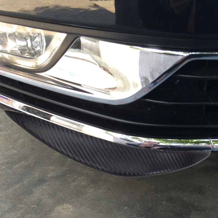 Black carbon-fiber bumper protector sticker installed on front lower car bumper