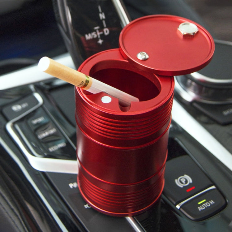 Red metal portable car trash bin/ashtray with open lid and cigarette resting inside