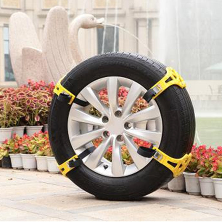 Car tire with yellow anti-skid chain wrapped around silver wheel rim