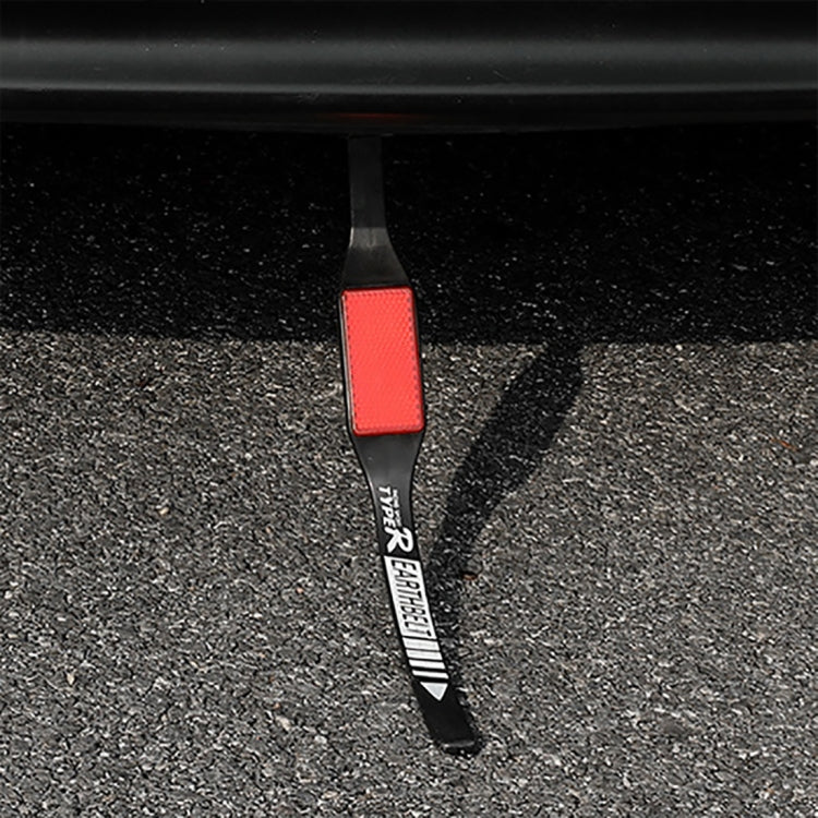 Car anti-static earth grounding strap with reflective red panel on asphalt ground