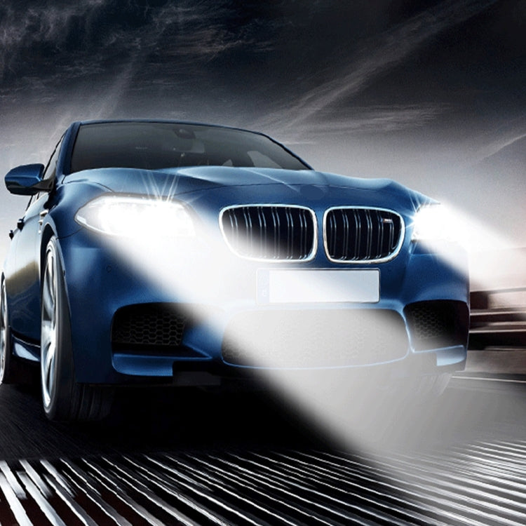 Car headlights illuminated by HID xenon bulbs with bright white beam on road