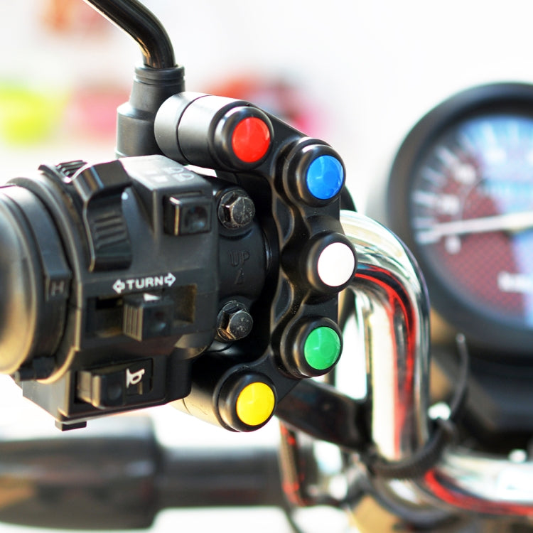 Handlebar auxiliary switch with black controls and colored buttons near headlight and switch module.