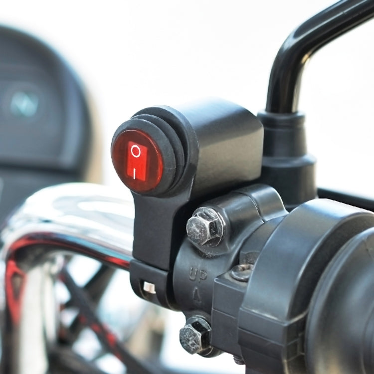 Close-up waterproof switch housing with red indicator lens and metal mounting bolts.