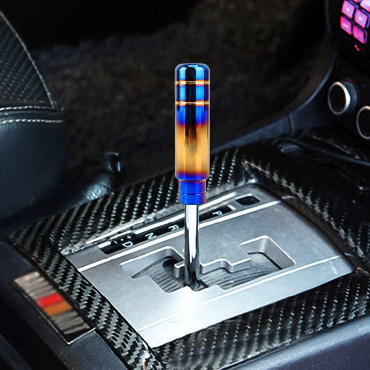 Colorful flame-style gear shift knob mounted on car interior panel with metallic shaft