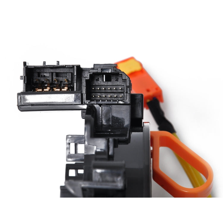Clock spring wiring connector module with black housing and orange lead, close-up detail