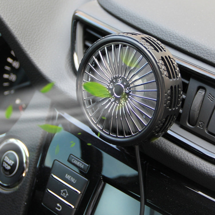 Close-up of black portable car fan mounted near air vent, with glowing fan blades
