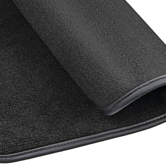 Close-up of black velvet car mat edge with gray trim and stitched border.