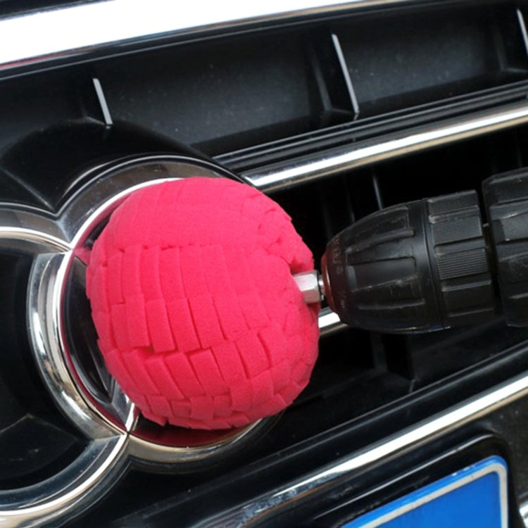 Red foam car polishing pad disc mounted on a handle for wheel rim detailing.
