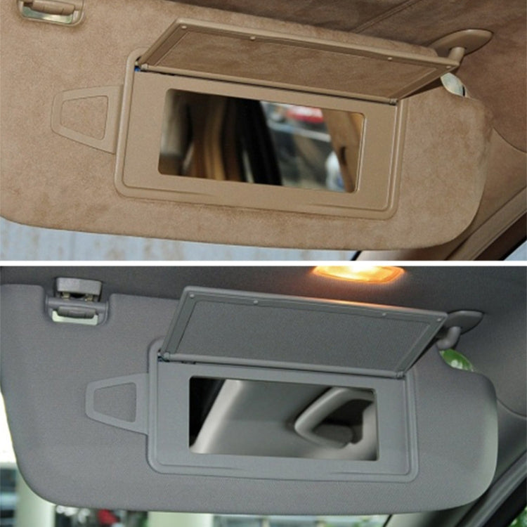 Beige sun visor vanity mirror installed on car with open viewing window