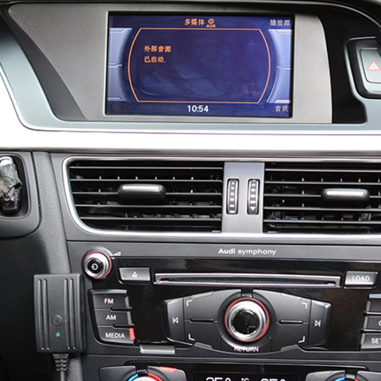 Car dashboard with connected wireless AUX control module beside audio controls