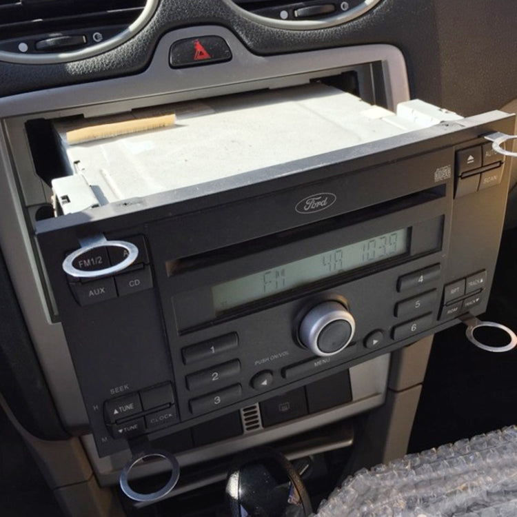 Car audio head unit partially pulled from the dashboard opening for service access
