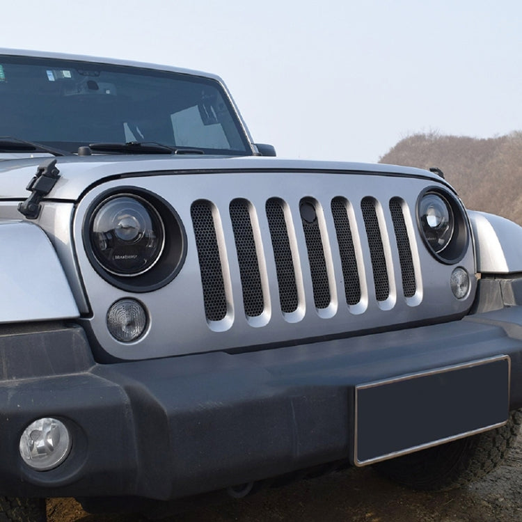 Installed black headlight covers on Jeep front grille, two circular lamp openings