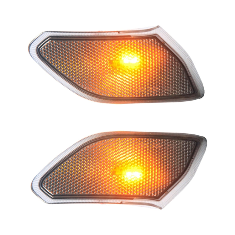 Front view pair of black turn signal side marker lamps with glowing amber lens