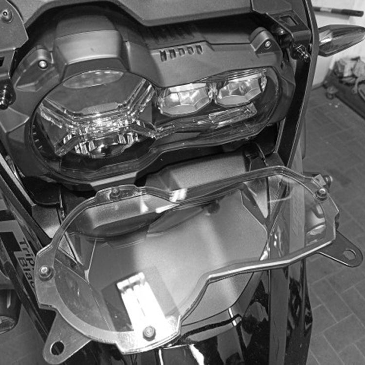 Installed motorcycle headlight protection cover with clear shield over dual lamps