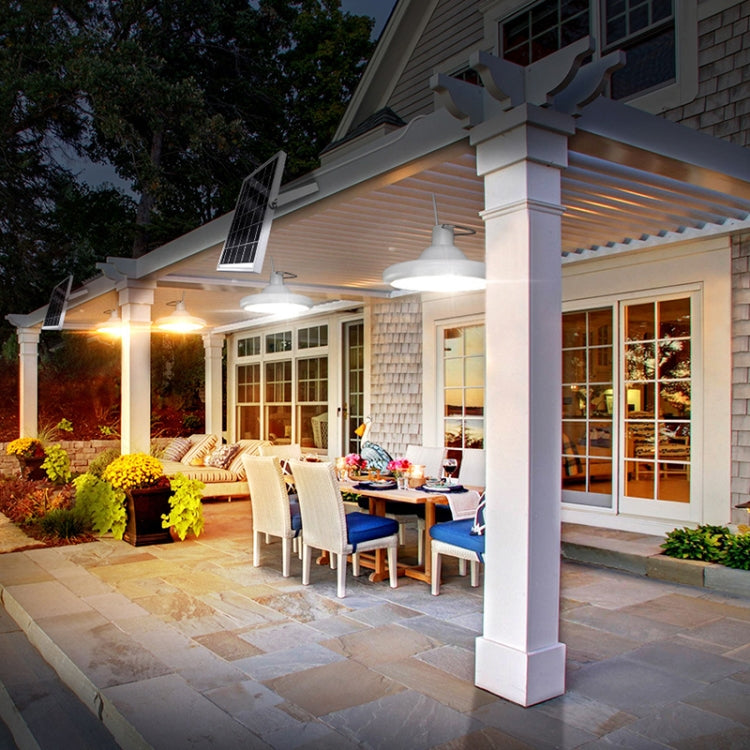 Solar LED outdoor patio light fixture with warm bulbs beside porch columns