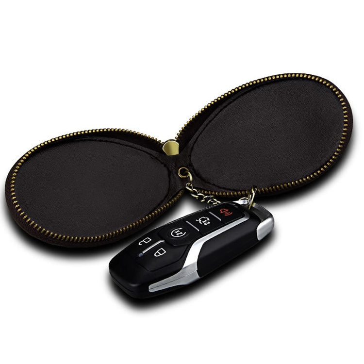 Dark brown leather key case with gold zipper holding a car key fob