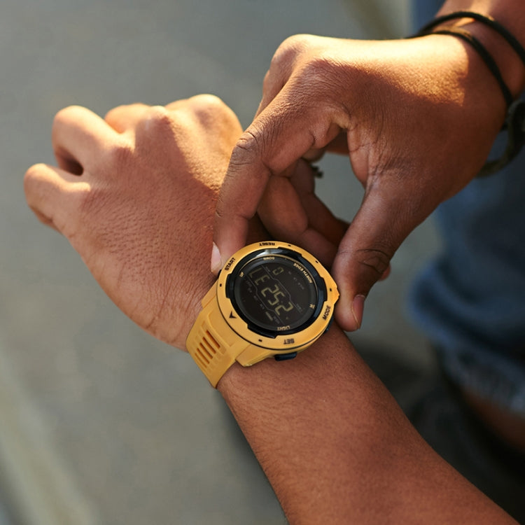 Yellow digital sports watch on wrist with black display and silicone strap