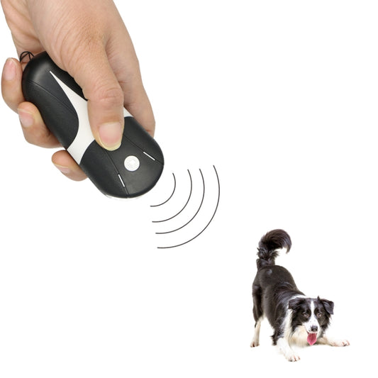 Handheld ultrasonic dog repeller, held in hand with sound-wave indicator, black and white.