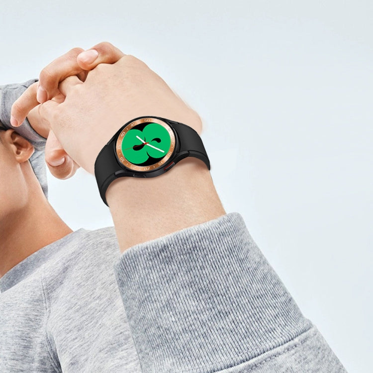 Smart watch steel bezel ring on a wrist with a gold ring and black watch strap.