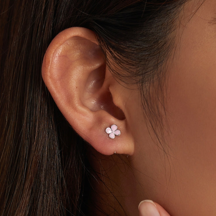 Sterling silver pink flower stud earrings with small three-petal enamel blooms on ear