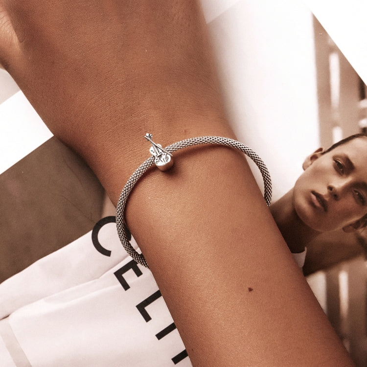 Sterling silver violin charm bracelet on wrist with mesh chain and clasp