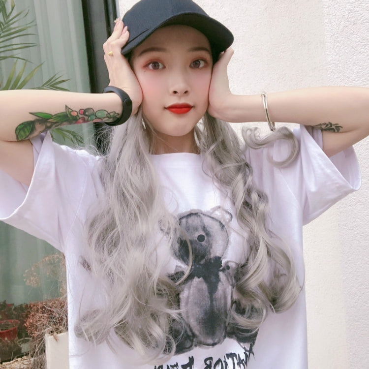 Light gray wavy curly wig with dark green baseball cap, hands on head