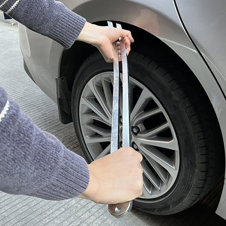 Paintless dent repair crowbar pressing on car fender near wheel, hands in use