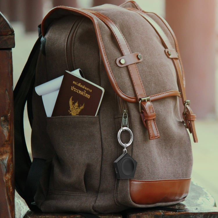 Black universal smart watch charger keychain attached to a backpack pocket