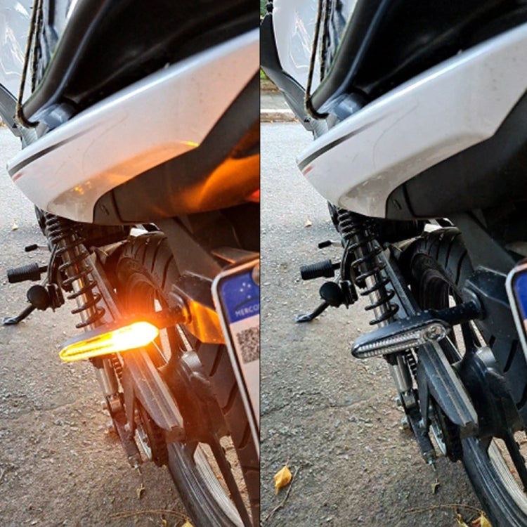 Motorcycle LED turn signals installed on bike front, amber light illuminated