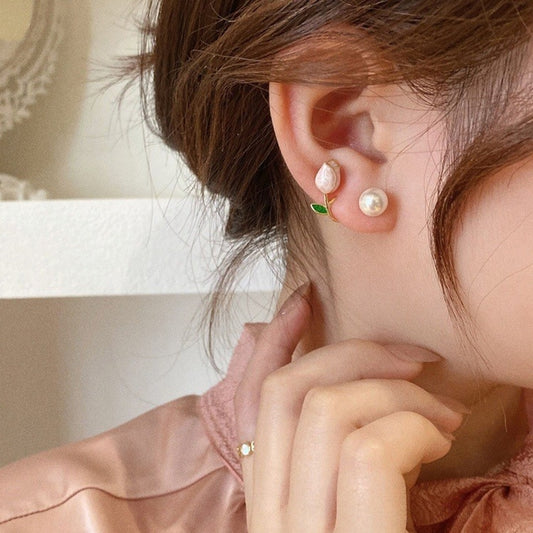 Pearl drop earrings with gold leaf detail and white pearl on ear