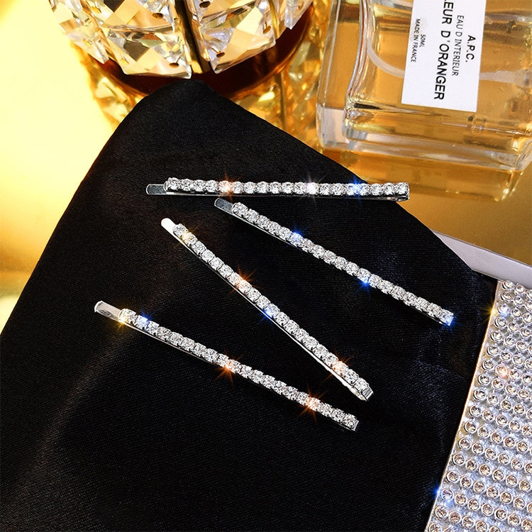 Four rhinestone bar hair clips, silver tones on black pouch