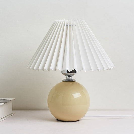 Beige ceramic desk lamp with white pleated lampshade, rounded globe base