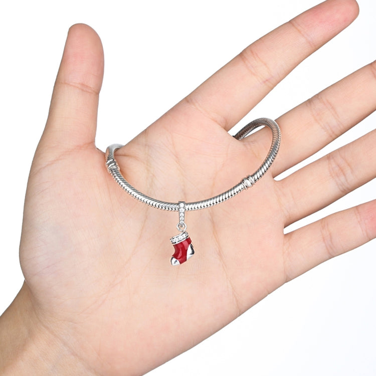 Charm bracelet with a small red enamel stocking bead hanging from the chain
